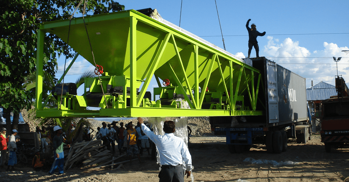 Workers operating mobile concrete plant on-site